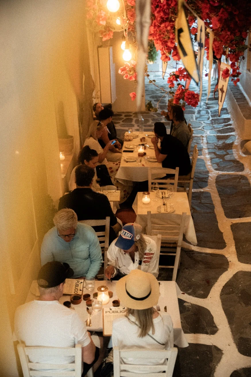 Romantic outdoor terrace at Pūblico restaurant, Mykonos Town — candlelit tables under bougainvillea